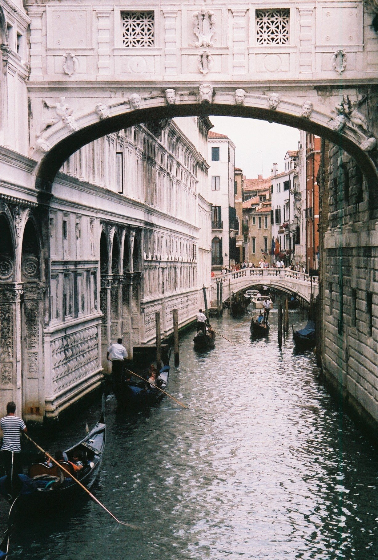 Destination Venice Discover hotels in Venice today with TicketSeller Προορισμός Βενετία Ανακάλυψε ξενοδοχεία στη Βενετία Κανάλια και γόνδολες στη Βενετία με τη Γέφυρα των Στεναγμών στο φόντο.