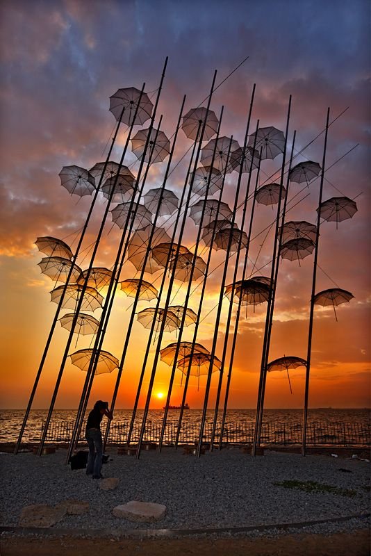 Umbrella sculpture by Giorgos Zongolopoulos at the Thessaloniki waterfront during sunset